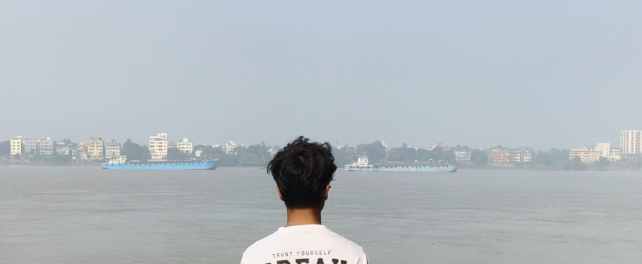 Ranit Mondal looking across a calm waterfront