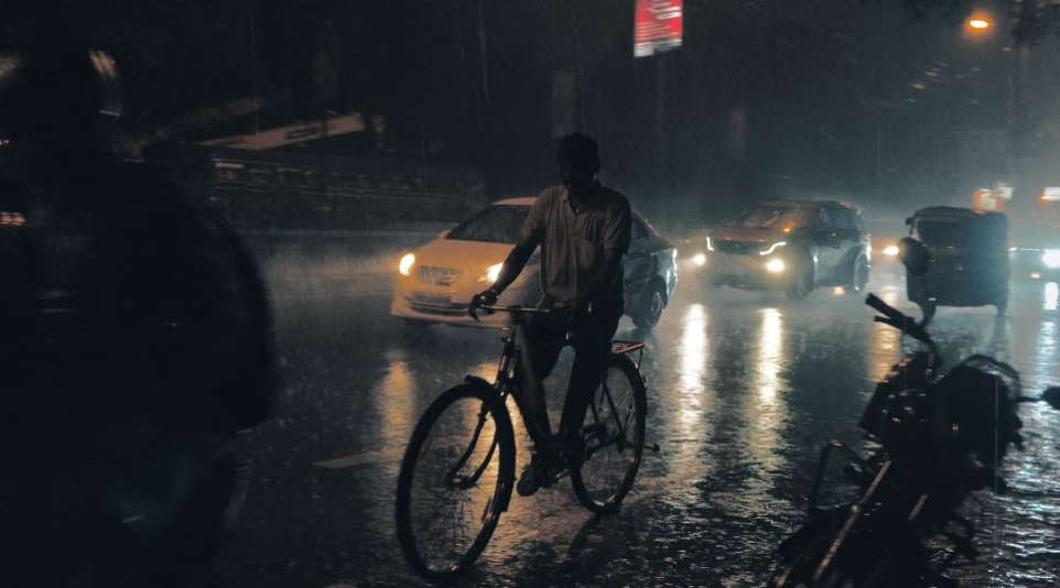 Person riding a bicycle on a rainy night
